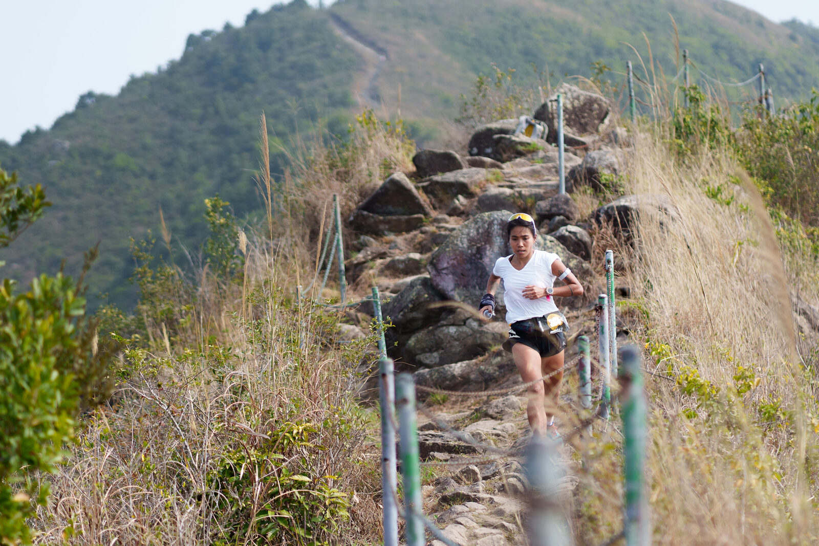 Runner climbing a rocky stepped trail
